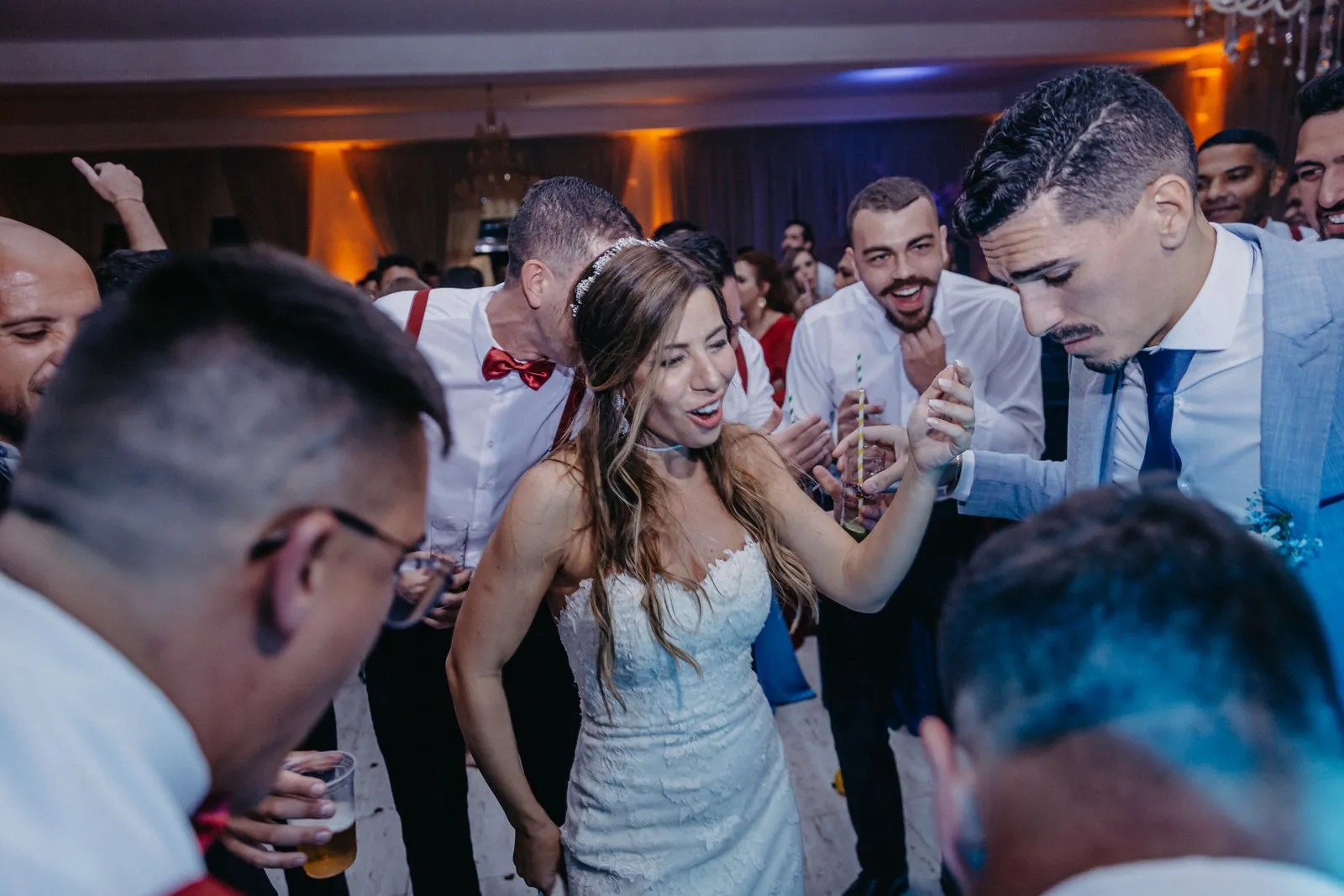 A vibrant scene of newlyweds dancing with guests at their wedding reception, full of joy and celebration.